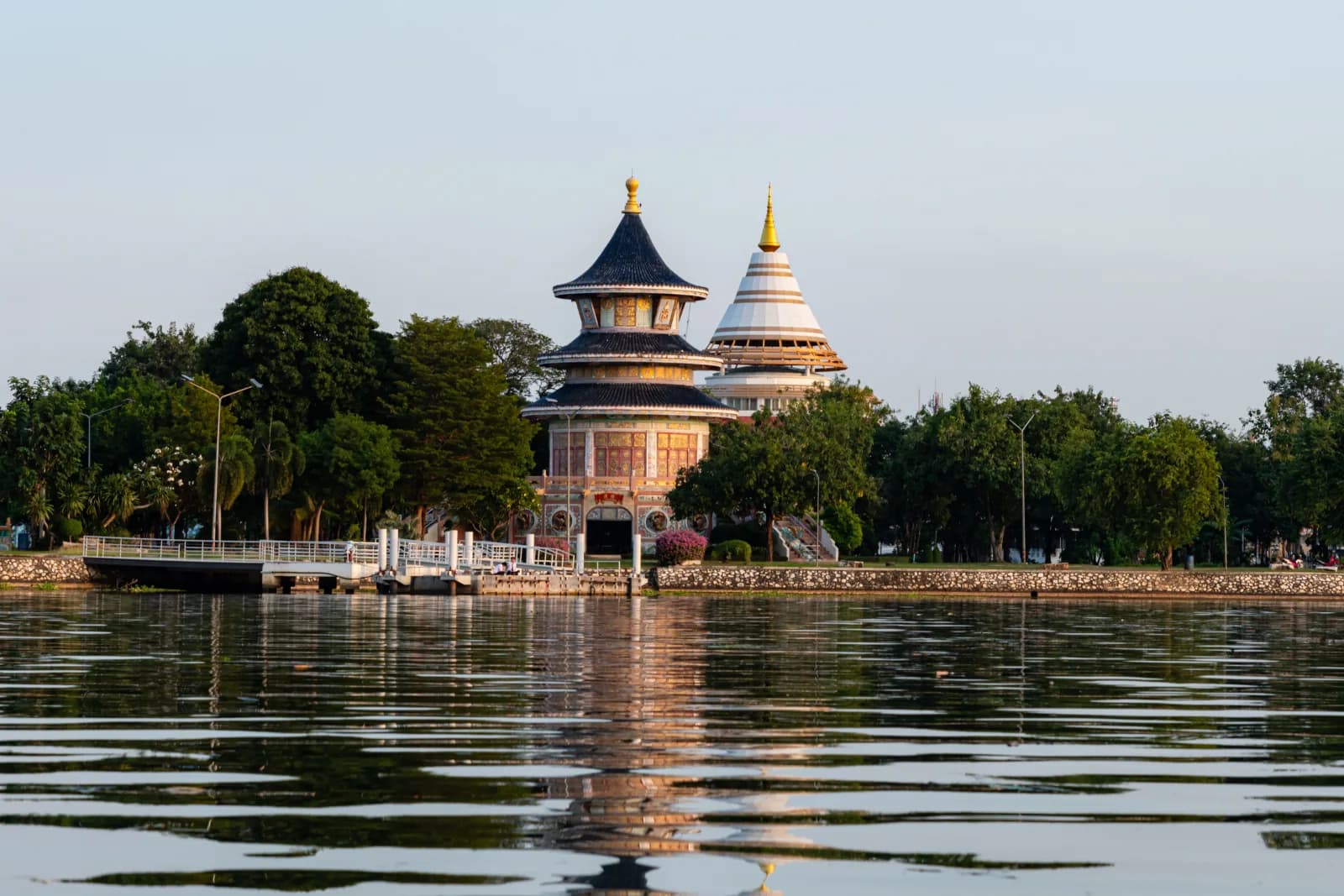 A Chinese pavilion and a white chedi reflected in Kanchanaburi's lake