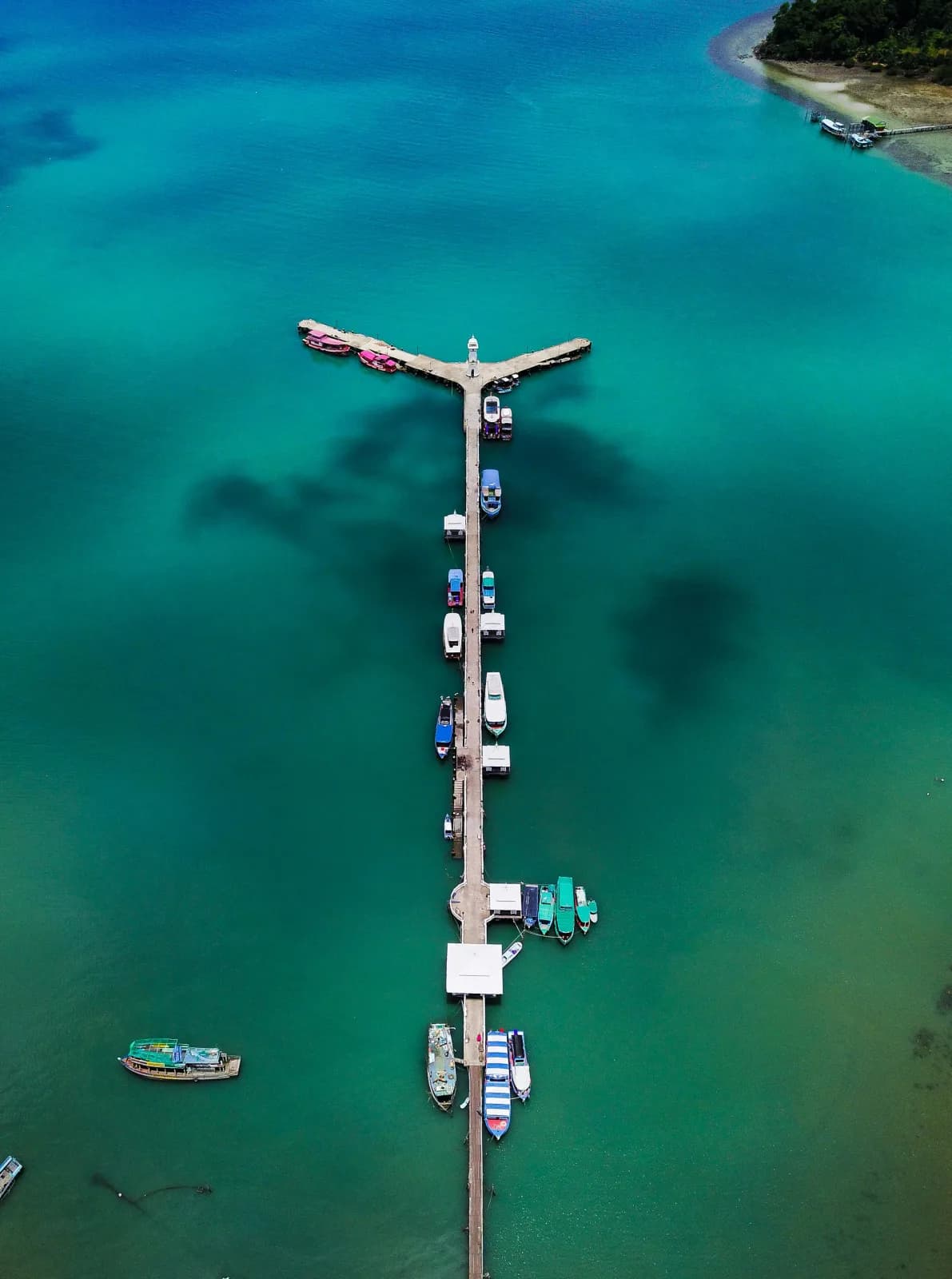 Long Ko Chang pier with boats in turquoise water, aerial view