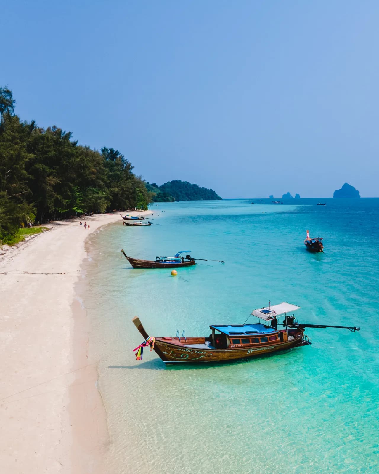 White sand and longtail boats at Koh Sirey island